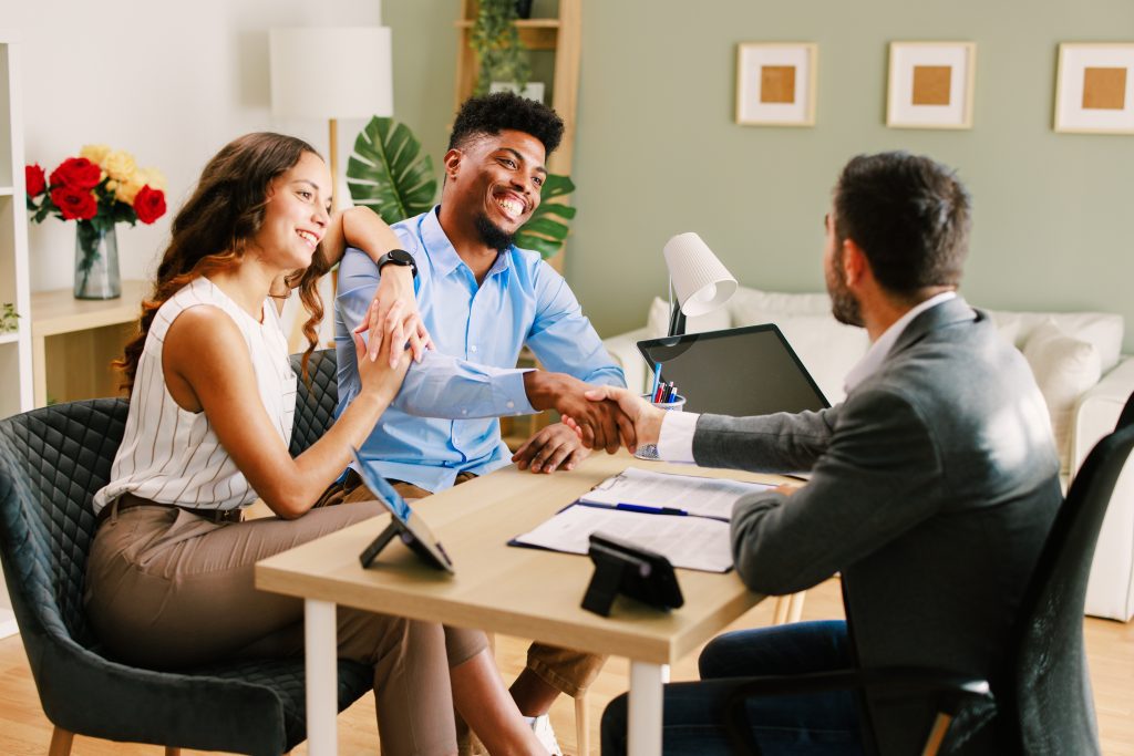 Mississippi REALTOR® meeting with homebuyers and shaking hands after discussing buyer representation and real estate services.